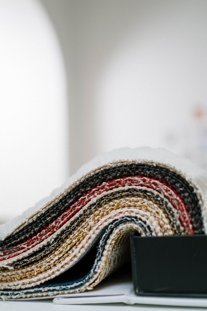 A detailed view of multicolored fabric samples displayed in a roll, showcasing intricate knitted textures.
