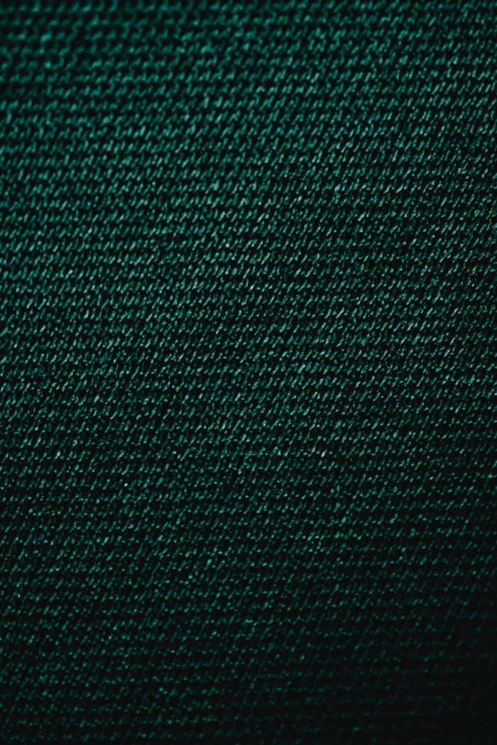 Detailed macro shot of green textile fabric showcasing its intricate texture.