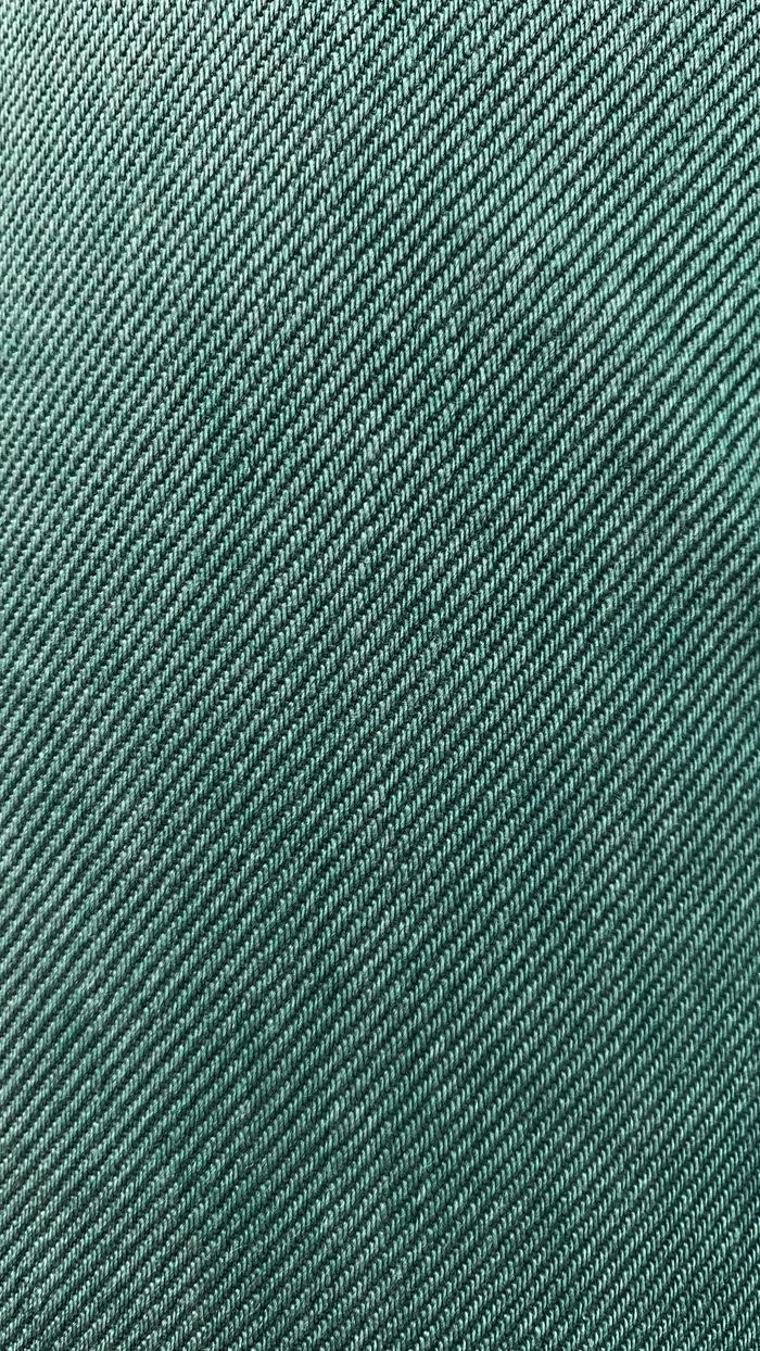 Detailed close-up of green fabric texture showing fine knit pattern.